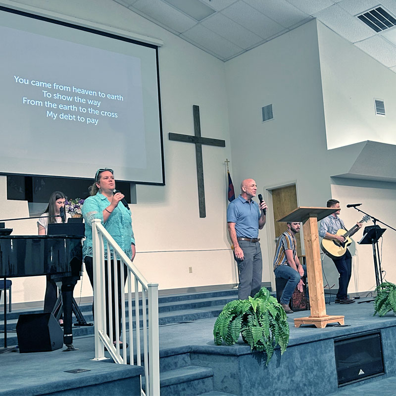 Members leading worship service of a mixture of hymns and contemporary songs praising God