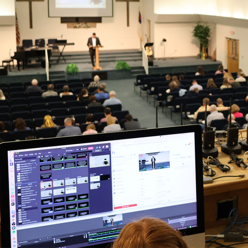 Audio / visual team in balcony streaming the live service through Facebook and Youtube
