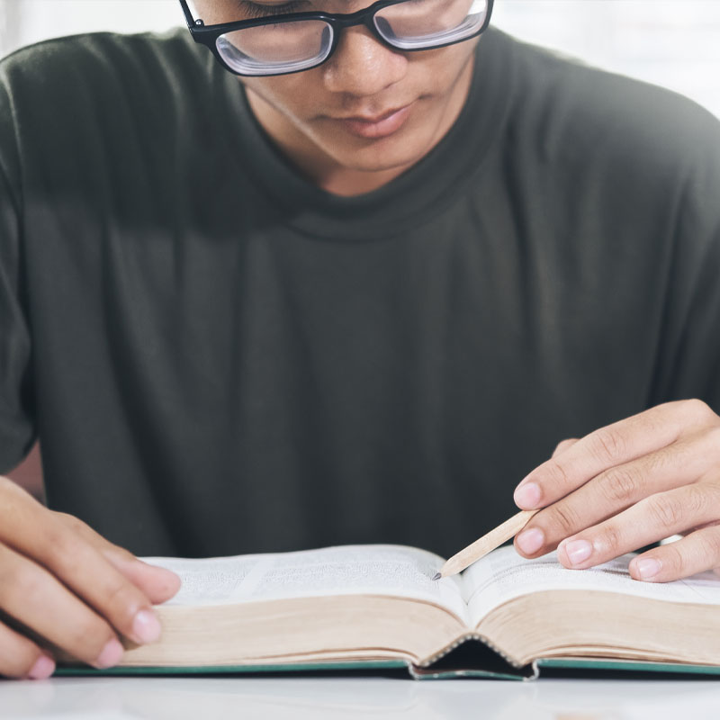 College and career student reading his bible