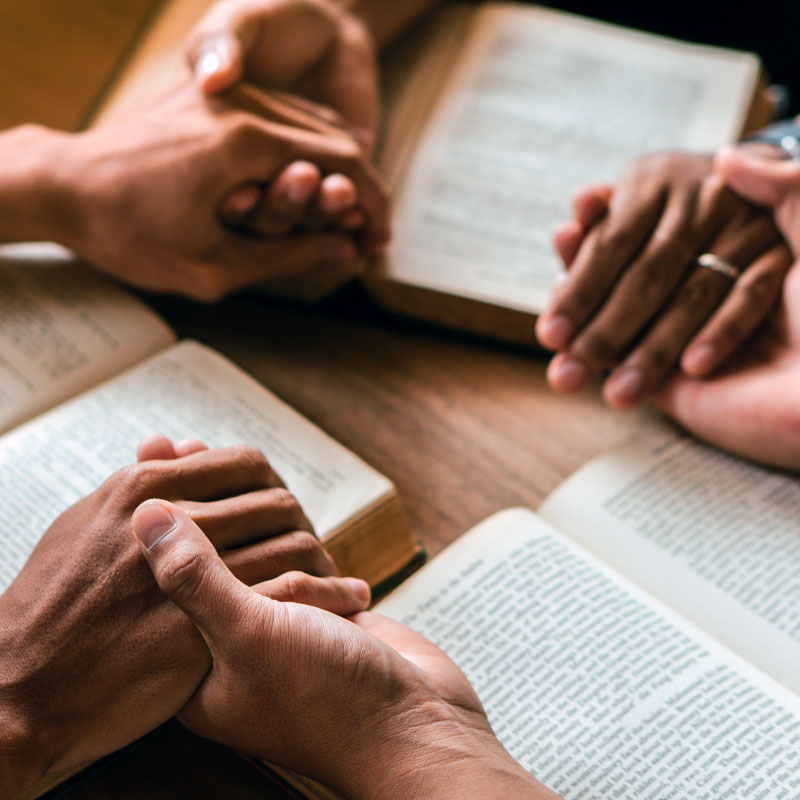 Group of christian people reading and study bible in home and pray together.Group of people holding hands praying worship god.