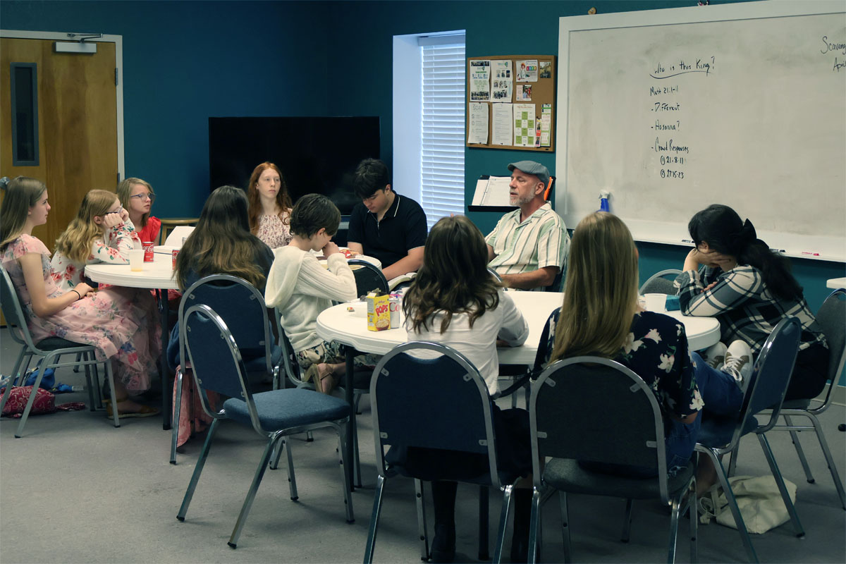 Youth group together learning a Biblical principal from youth leader