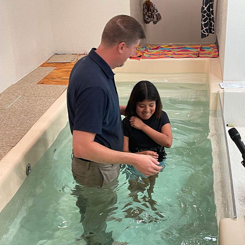 A child being baptized by Pastor Kevin after they received Jesus into their hear
