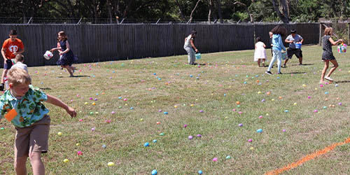 children picking up easter eggs and filling their basket on Palm Sunday at Trinity Baptist Church Lakeland, FL.