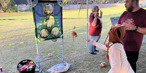 Girl tossing a soft football into a net at fall festival at Trinity Baptist Church in Lakeland. Baptist church lakeland.