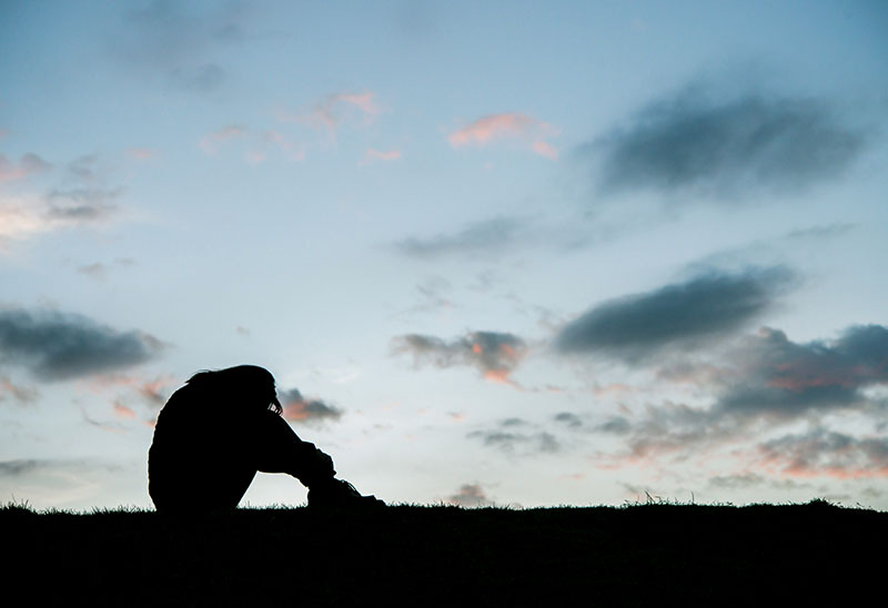 A silhouette of a person with the sky in the background.
