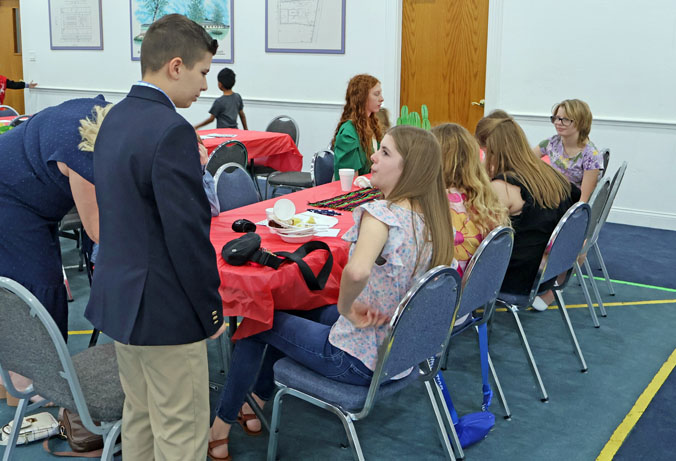 Youth age group of teens at Trinity Baptist Church of Lakeland sitting at a table during a youth fundraiser